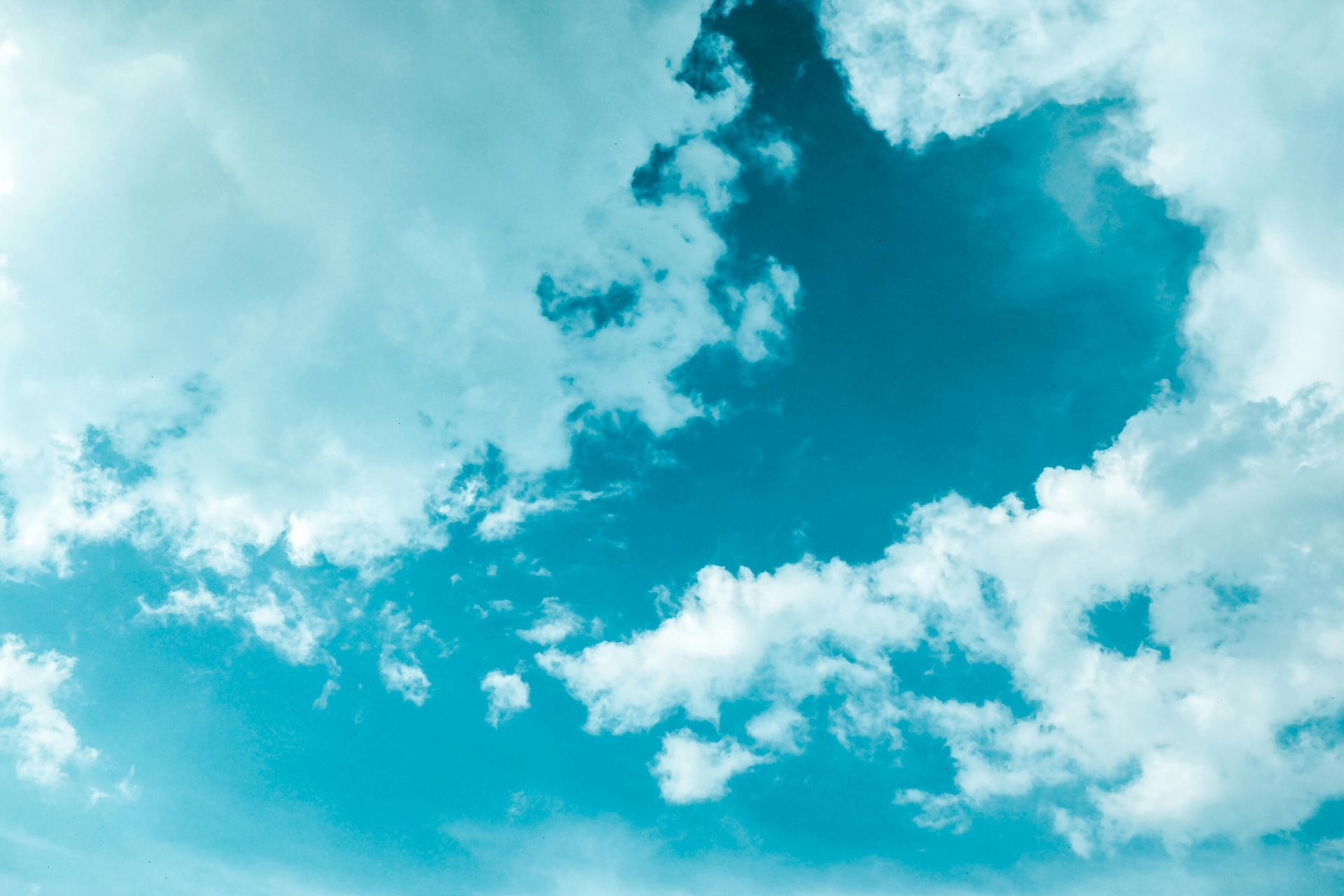 Blauwe lucht met donzige witte wolken.
