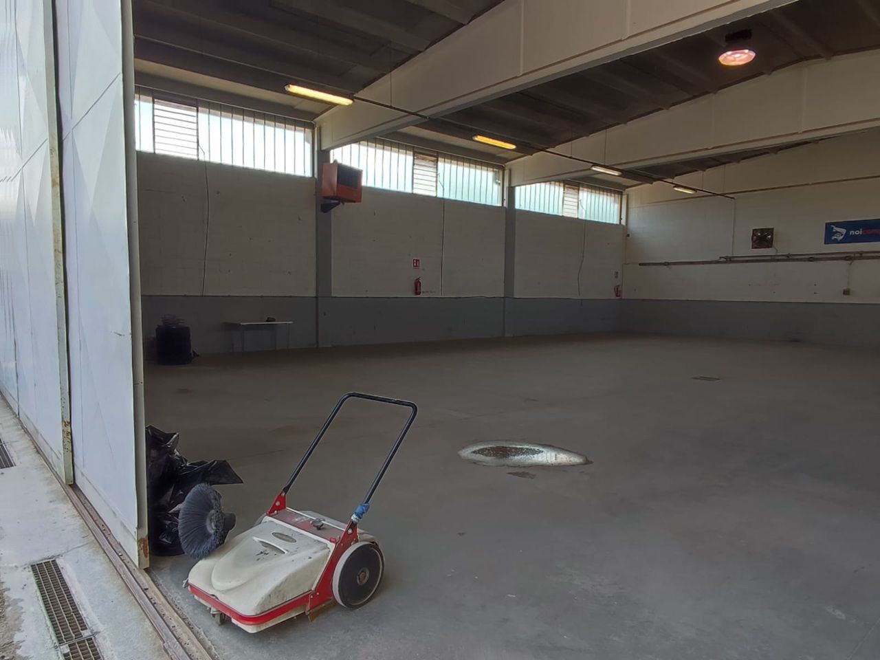 Palestra interna vuota con un tosaerba a spinta vicino alla parete sinistra.