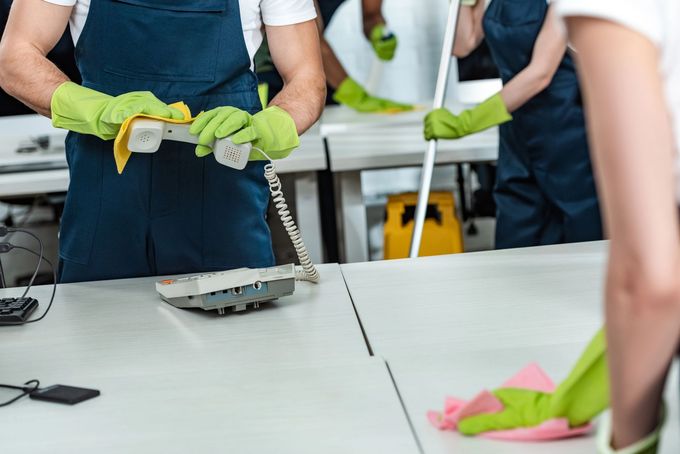Persone con i guanti che preparano il cibo su un bancone della cucina con utensili e ingredienti