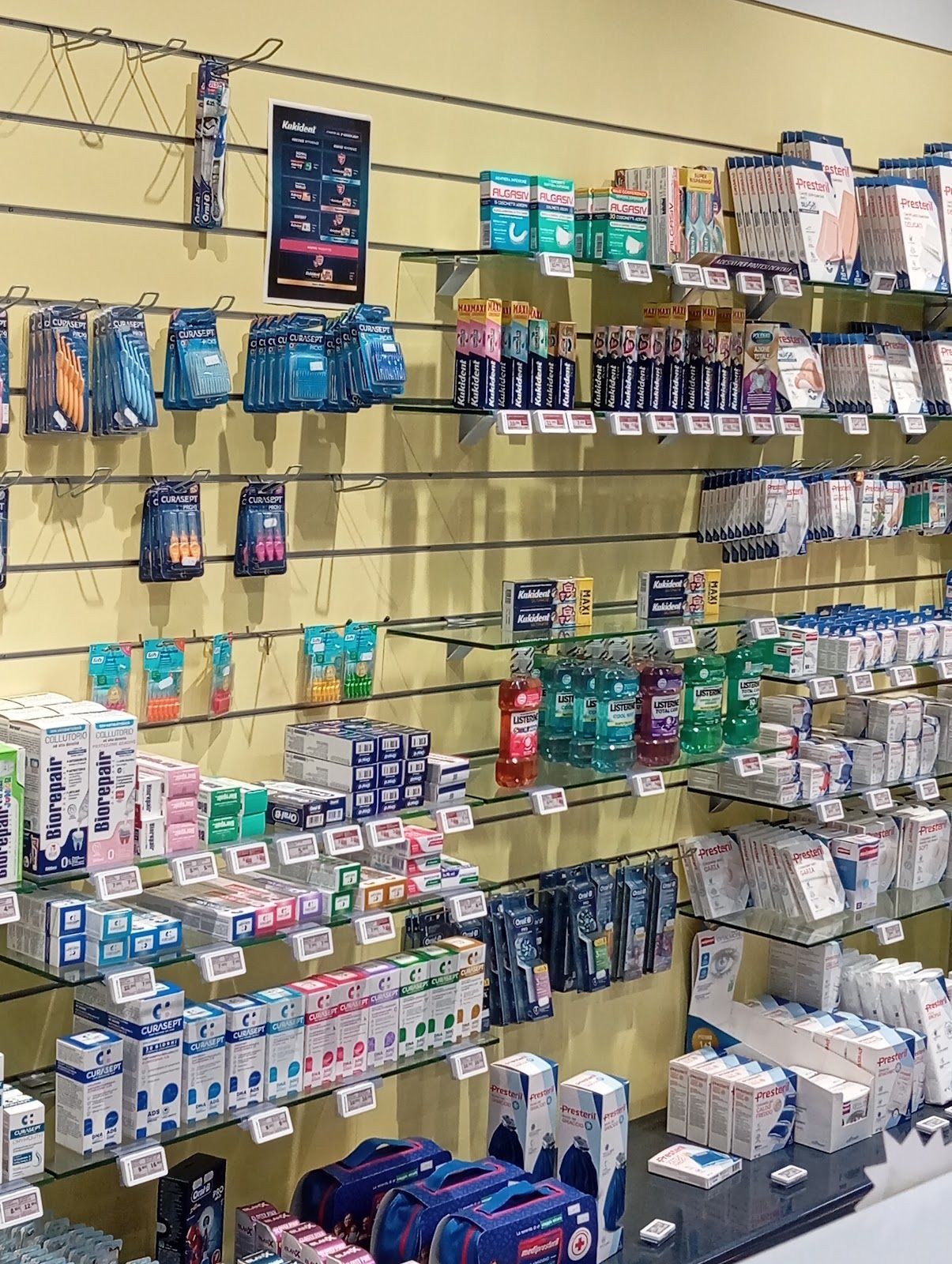 Parete del negozio rifornita con un assortimento di articoli da toeletta e prodotti per la cura personale disposti su scaffali e ganci.