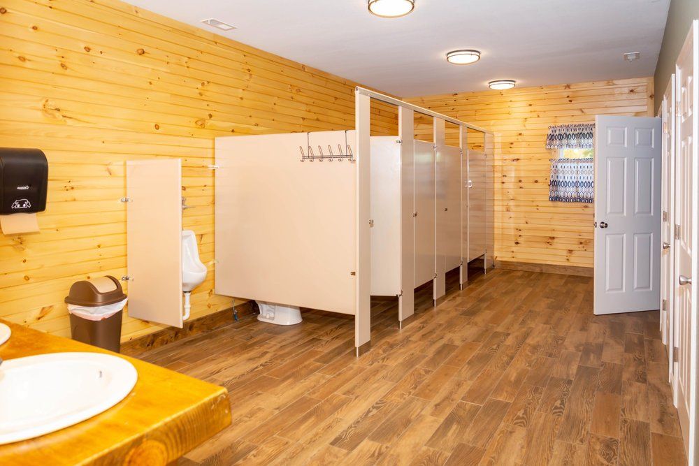 A cabin bathroom with stalls and wood paneled walls