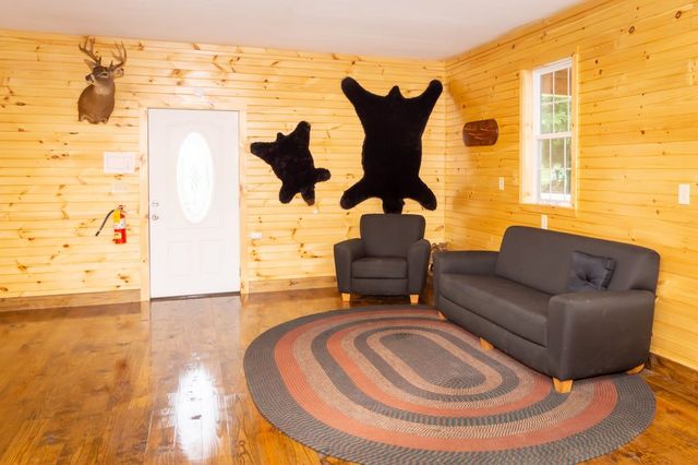 A lounge with a sofa, armchair and braided rug