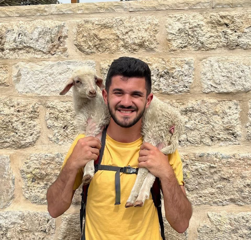 Connor Roberts, Camp Director, with a lamb over his shoulders