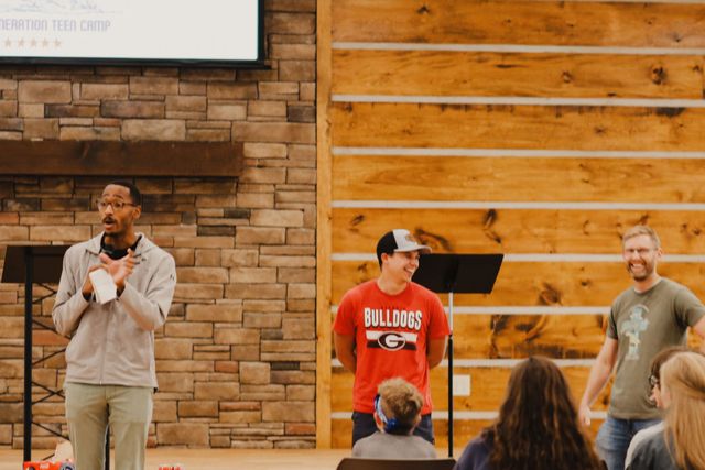 Speakers at the front of the Chapel with campers listening