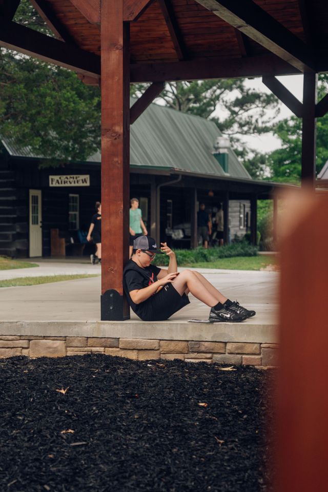 A camper sitting on a curb near the pavilion