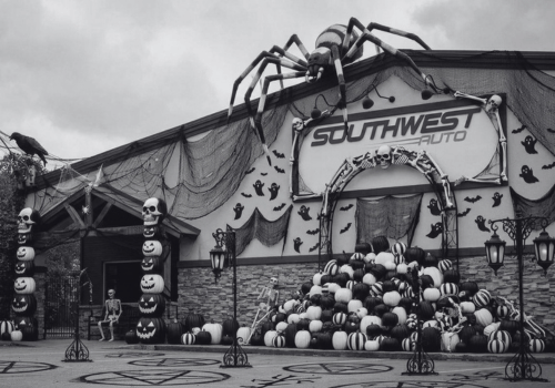 Southwest Auto repair shop decorated for Halloween with giant spiders, cobwebs, skeletons, skulls