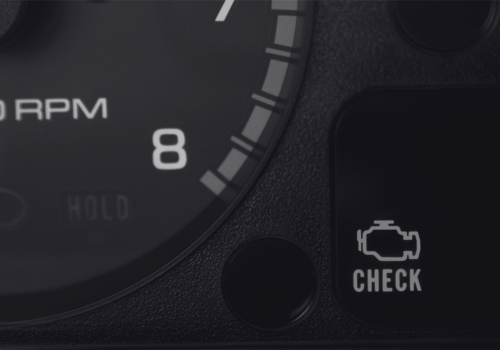Car dashboard tachometer and check engine warning light illuminated