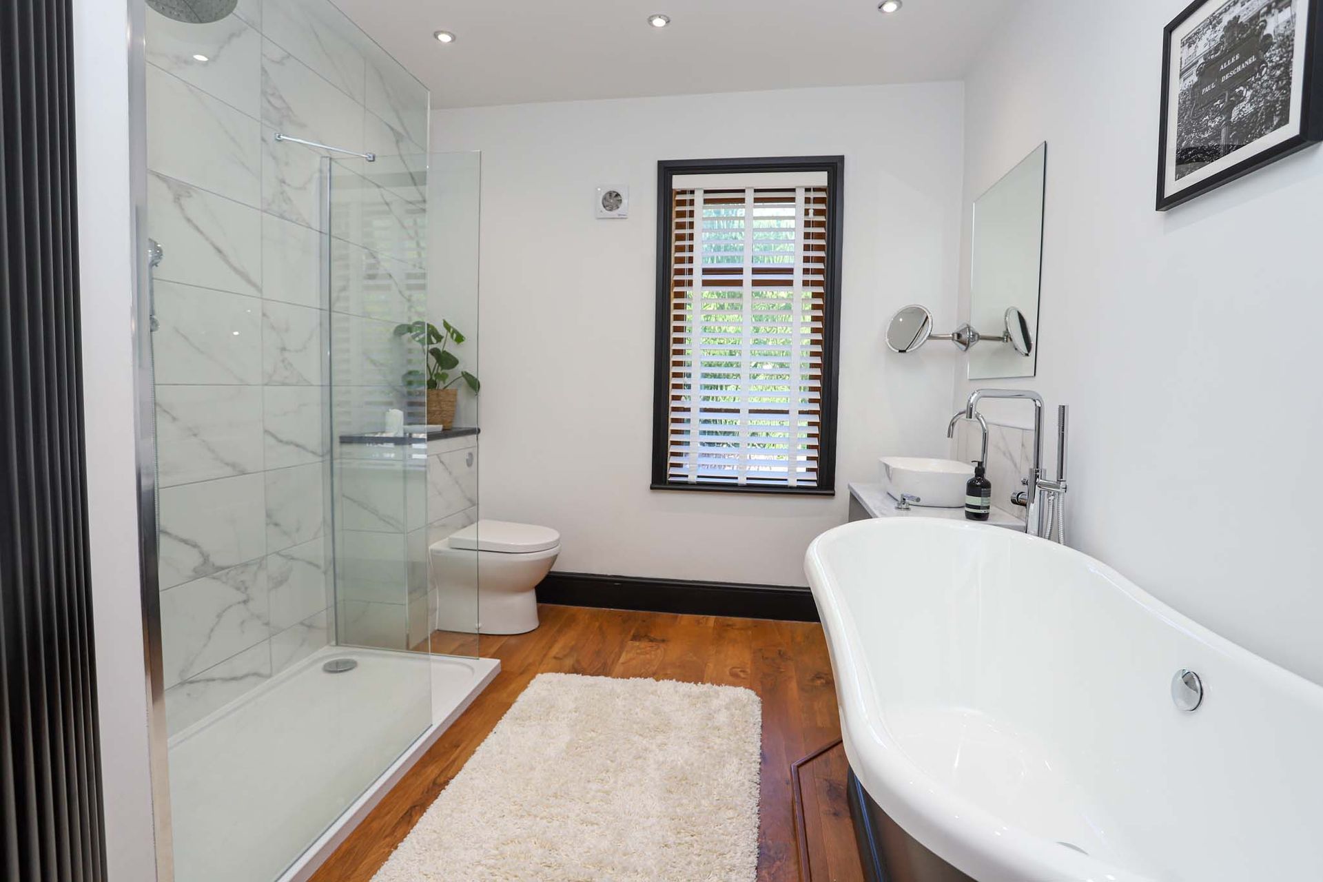 A bathroom with a bathtub , sink , and window.