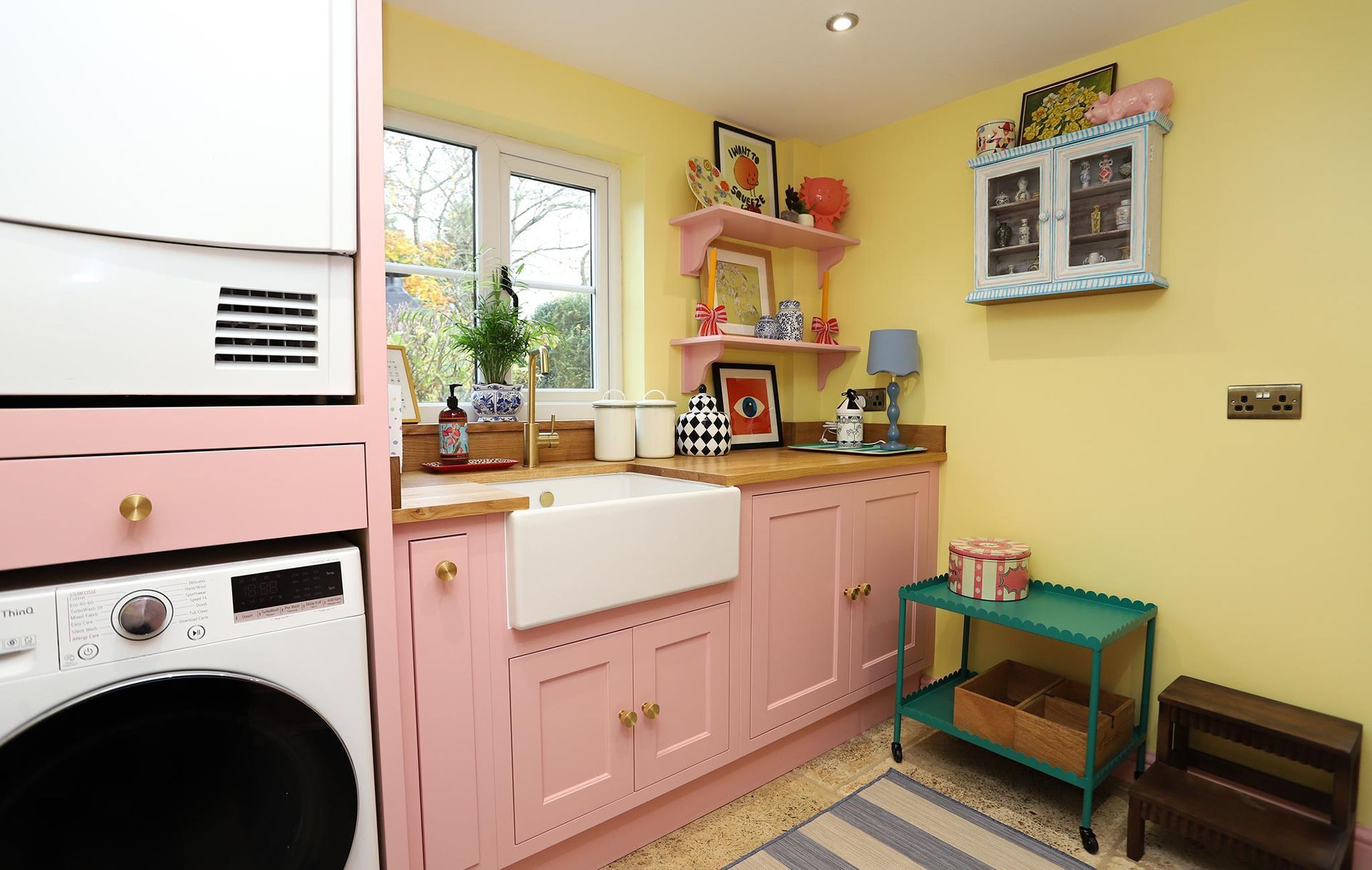 A kitchen with pink cabinets and a white sink