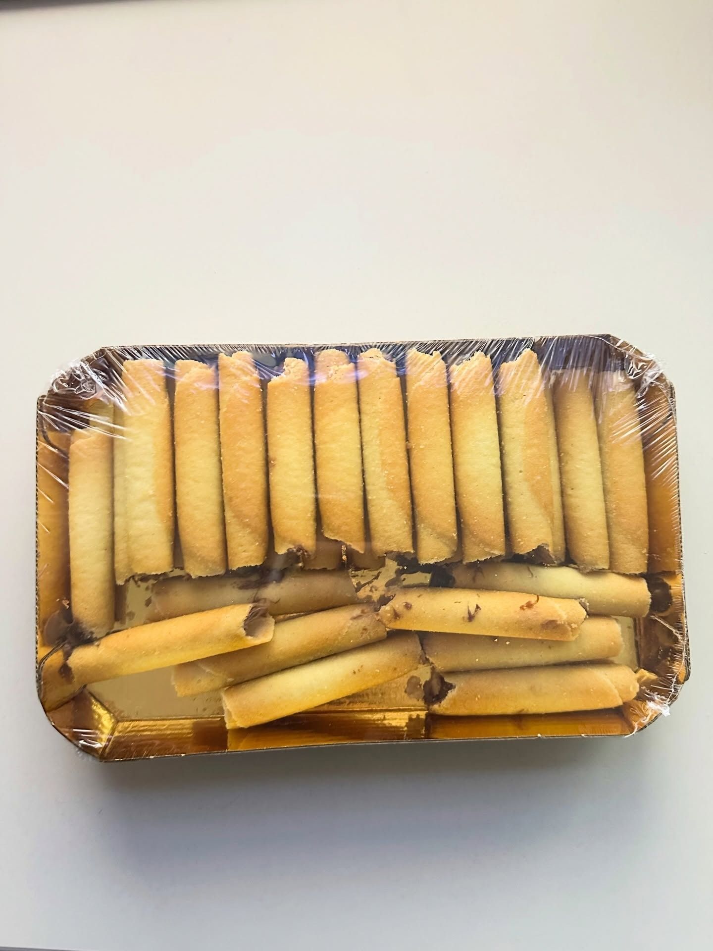 Vassoio di alluminio con grissini e pasticcini arrotolati disposti in file