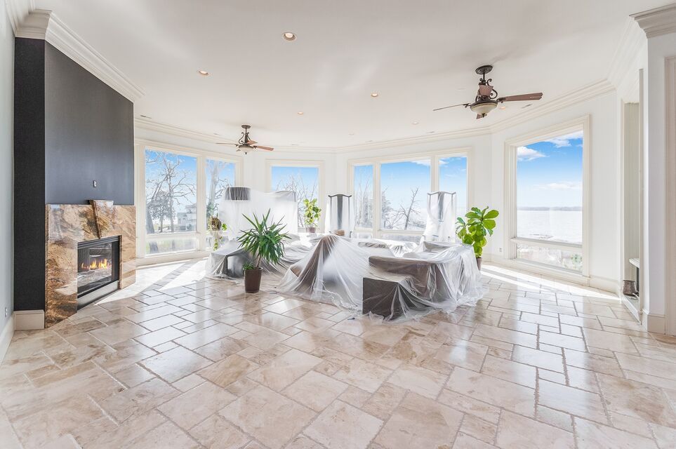 Bright modern dining room with large windows, tiled floor, ceiling fans, and potted plants