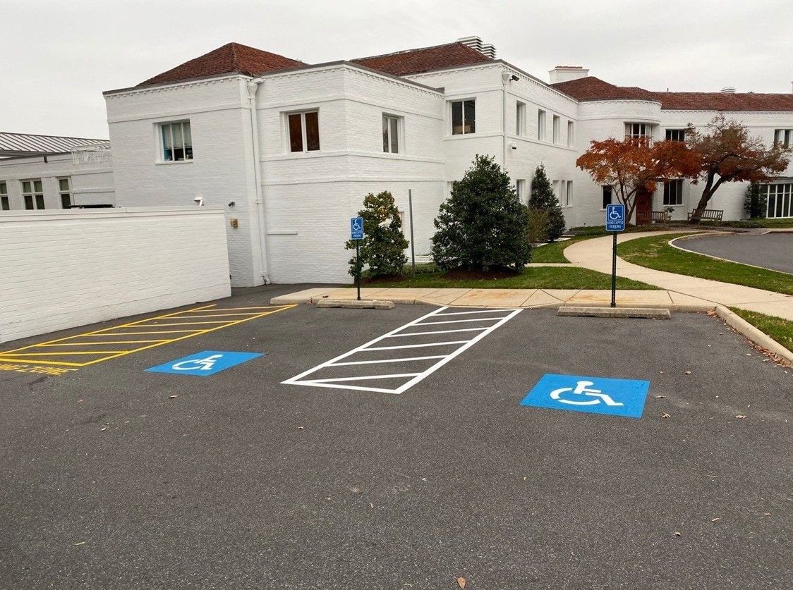 Accessible parking spaces outside a white building near an entrance
