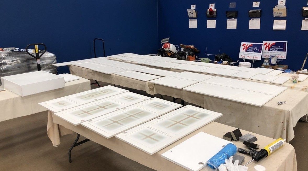 Tables covered with papers and supplies in a room with blue walls and hanging displays