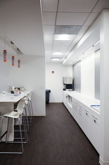 Bright office hallway with desks on the left and windows on the right