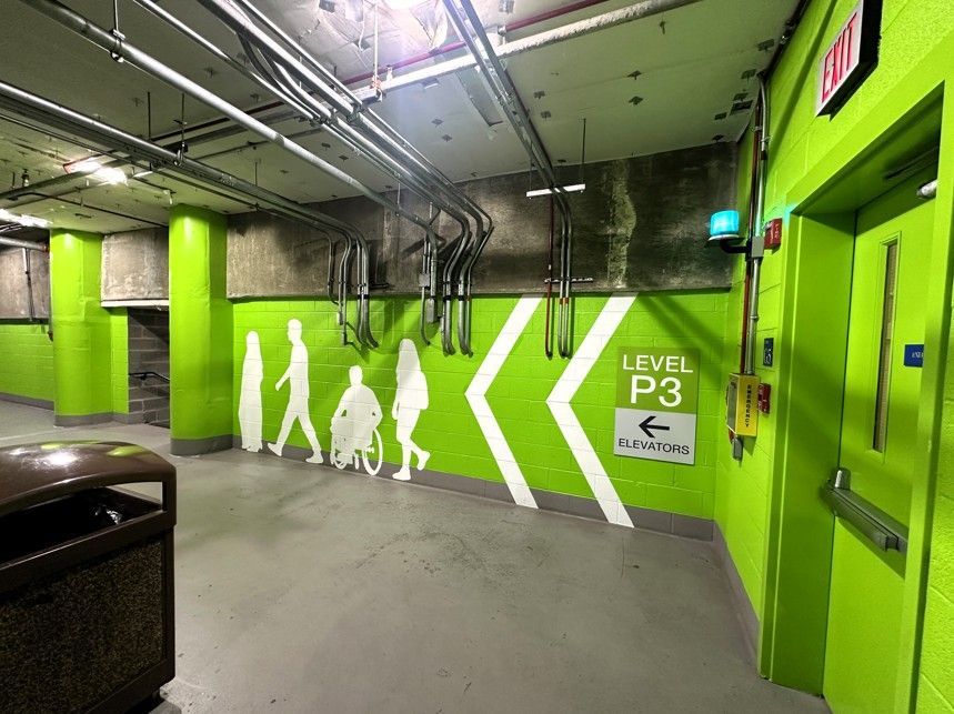 Bright green parking garage corridor with white pedestrian silhouettes and “LEVEL P3” sign