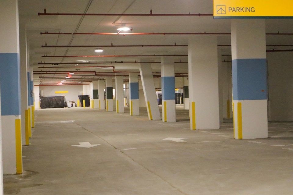 Empty indoor parking garage with concrete pillars and fluorescent lights