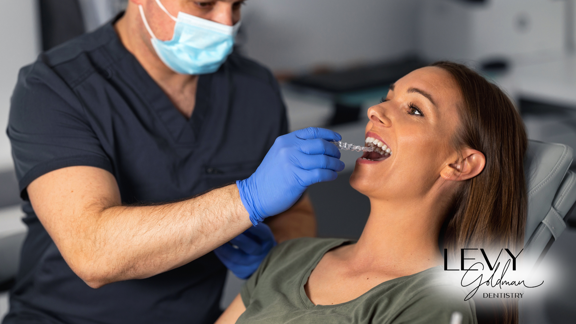 A woman is sitting in a dental chair getting her teeth examined by a dentist.