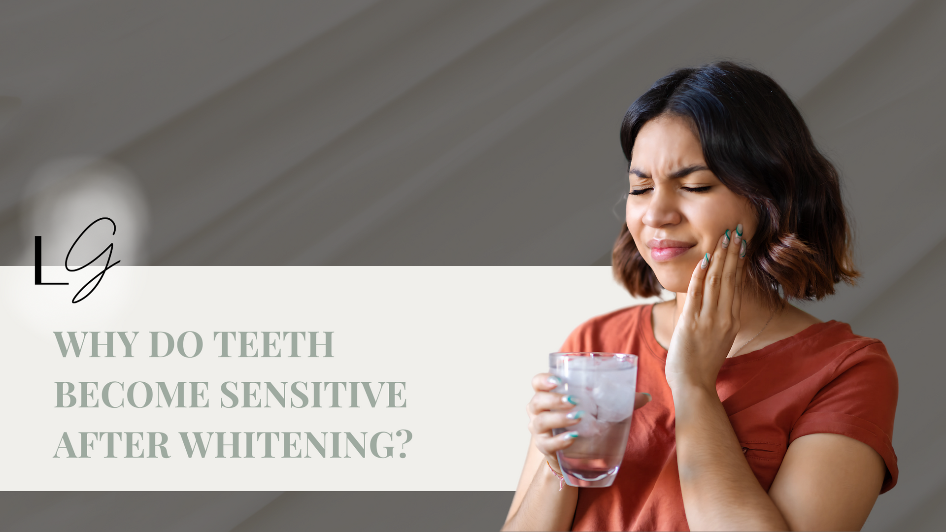 A woman is holding her mouth in pain while holding a glass of water.