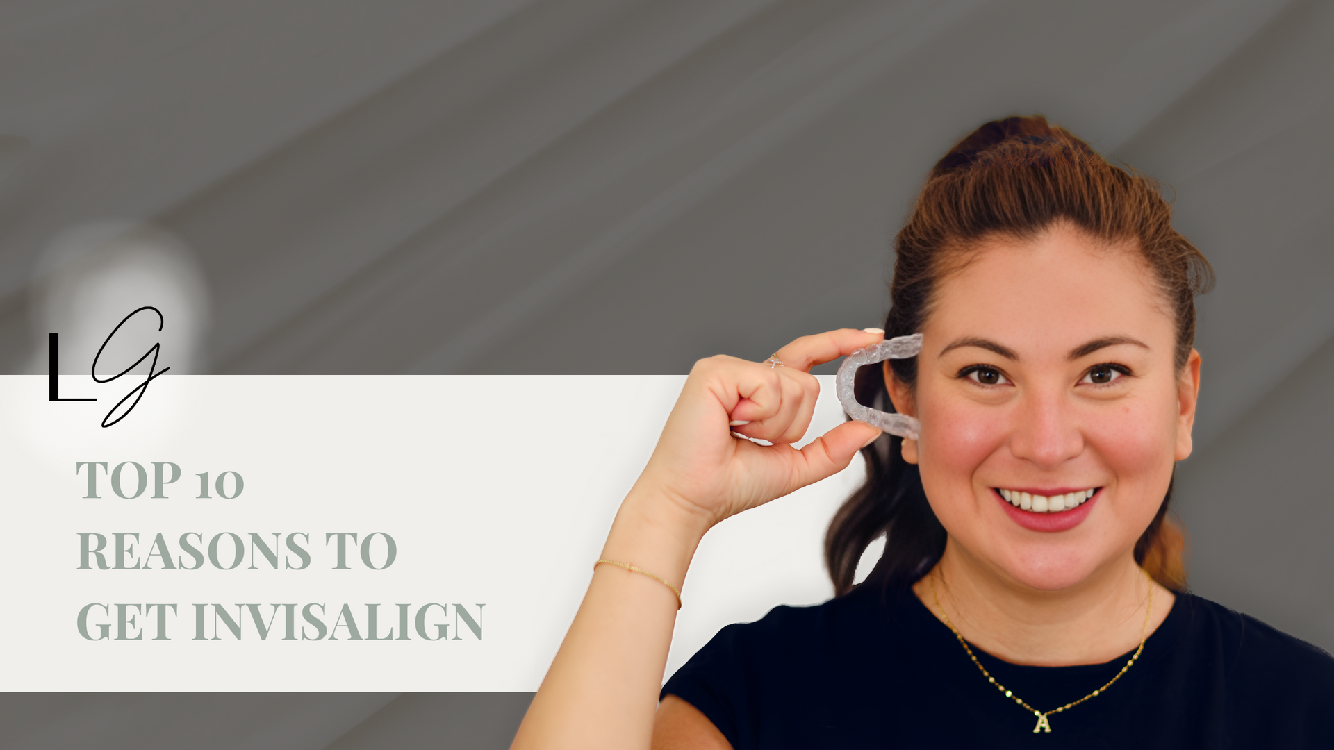 A woman is holding a clear retainer in her hand.