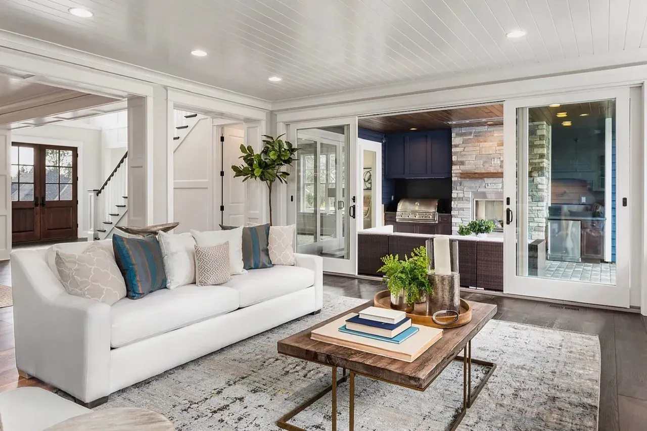 A living room with a white couch and a wooden coffee table.