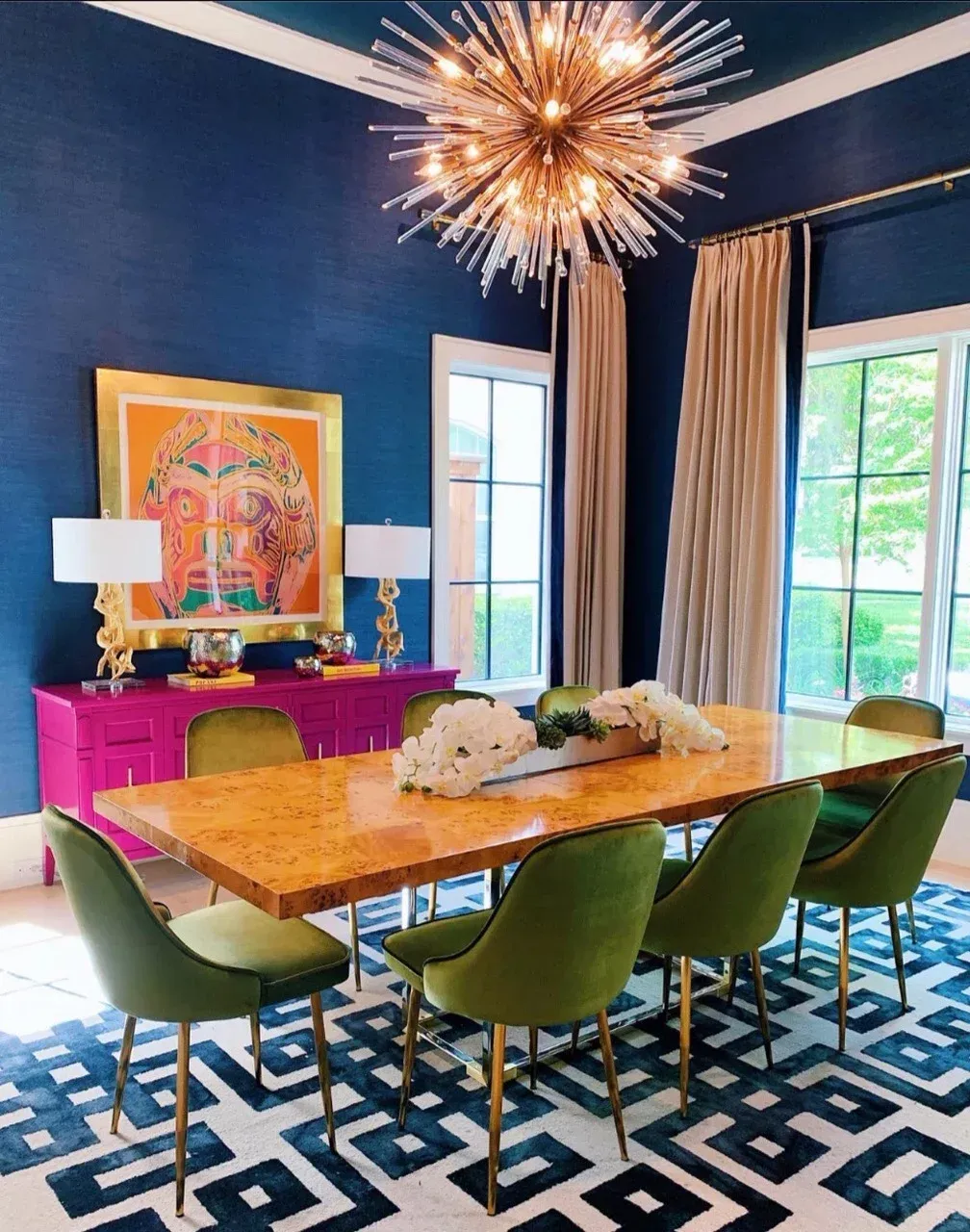 A dining room with a long table and green chairs