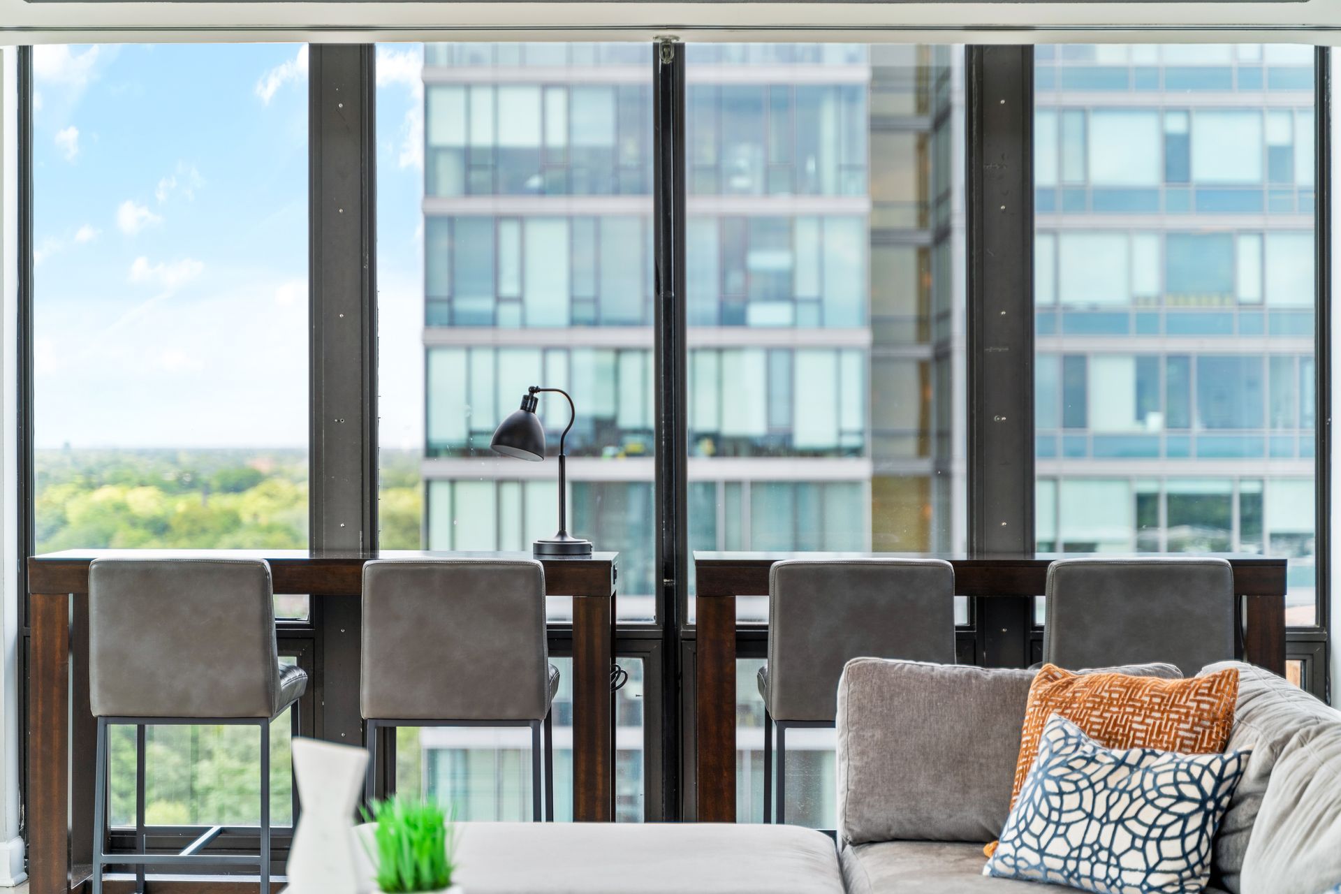 two tables with four bar chairs in front of floor-to-ceiling windows facing a building in Oak Park, IL