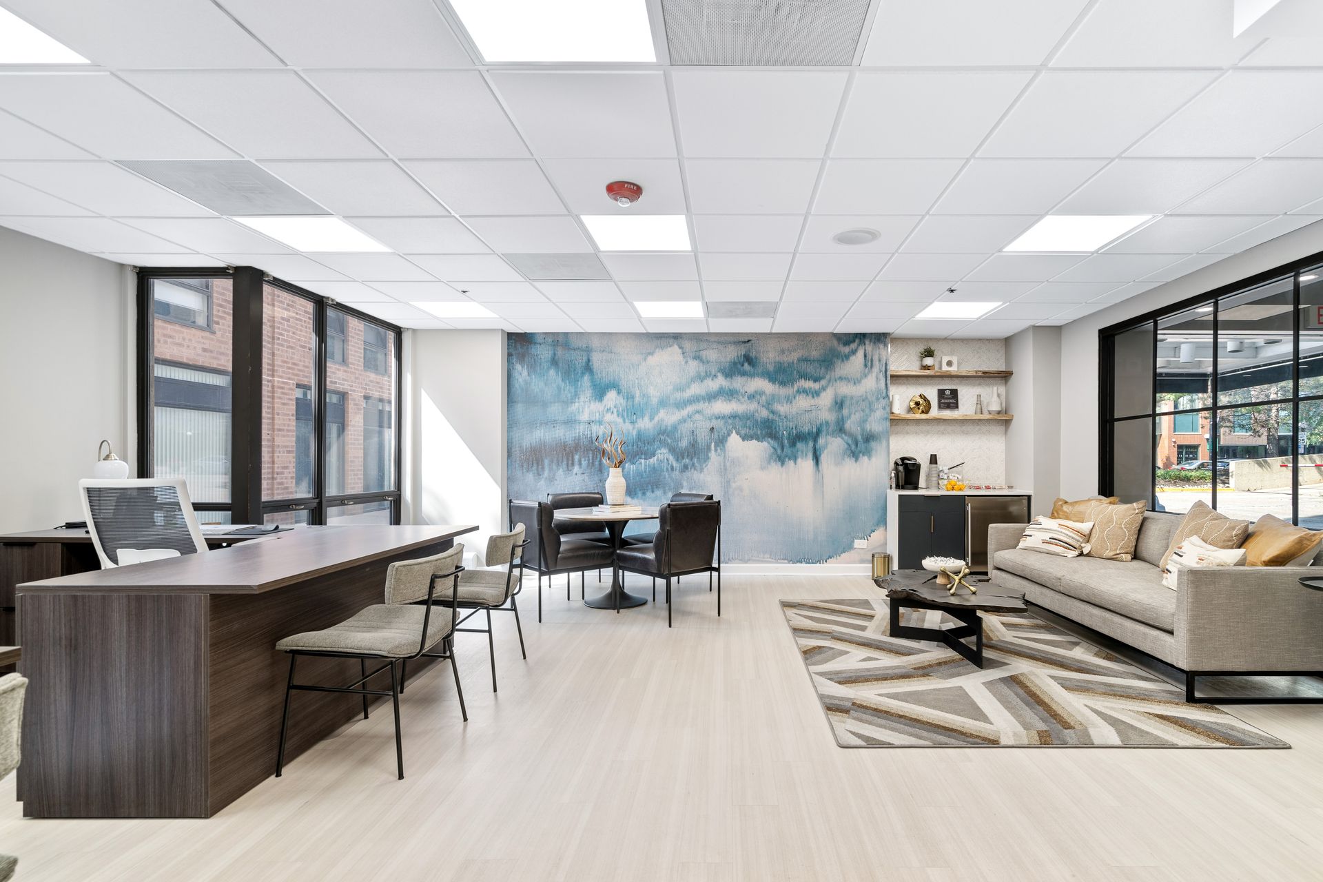 a desk and lounge area in the leasing center of 100 Forest Place in Oak Park, IL