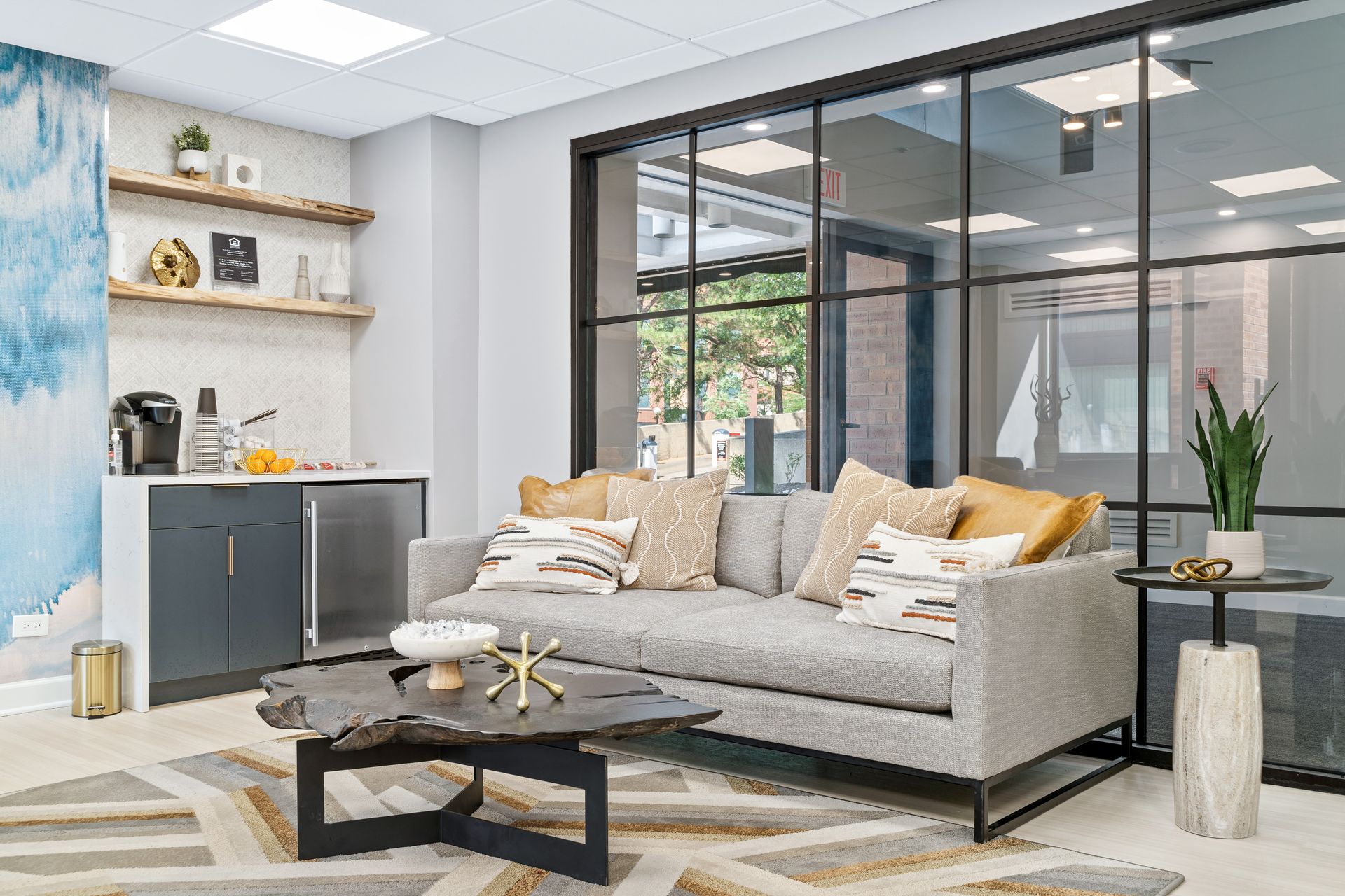 gray couch next to a coffee bar in the community clubroom at 100 Forest Place
