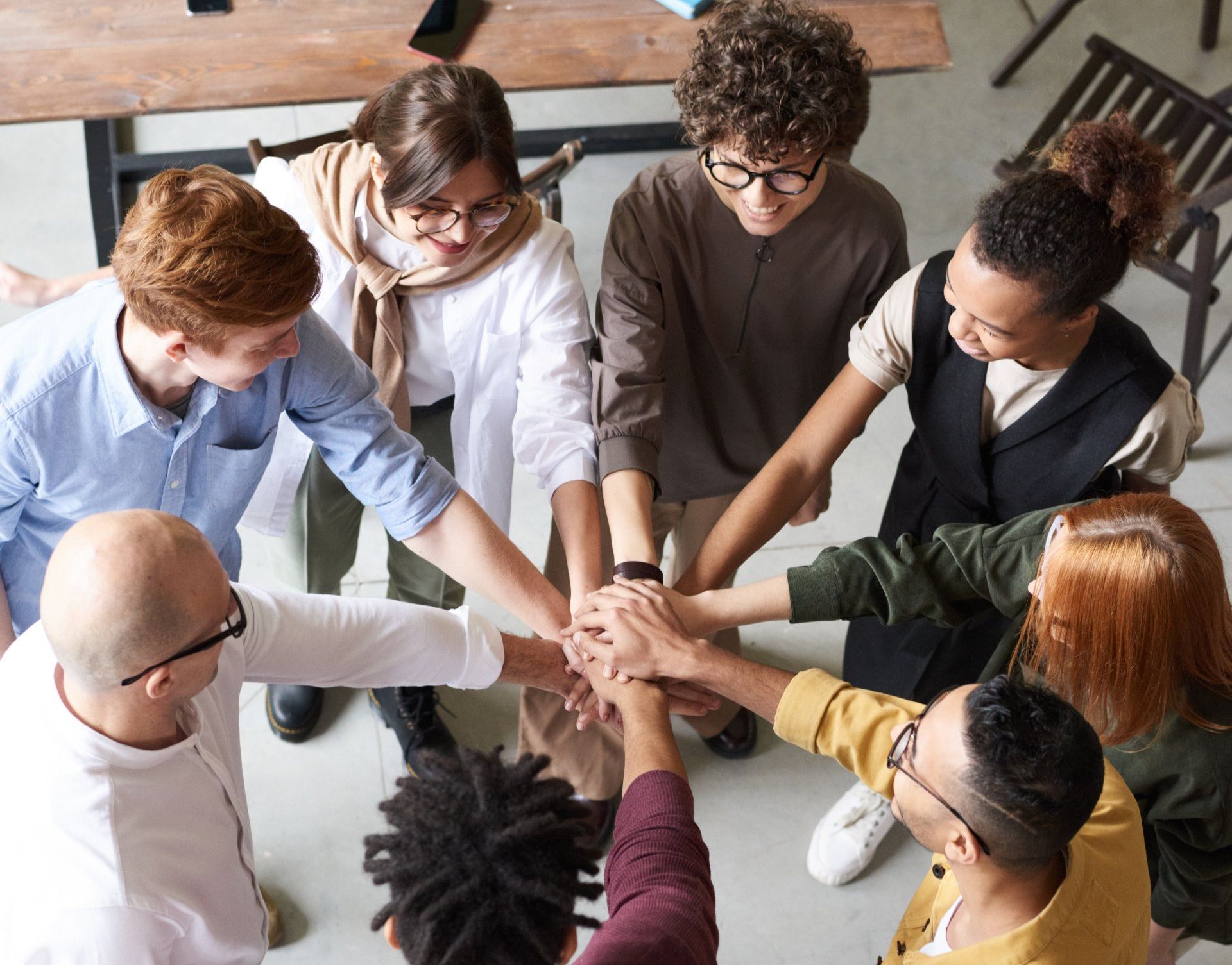 people stacking their hands in the middle of a circle