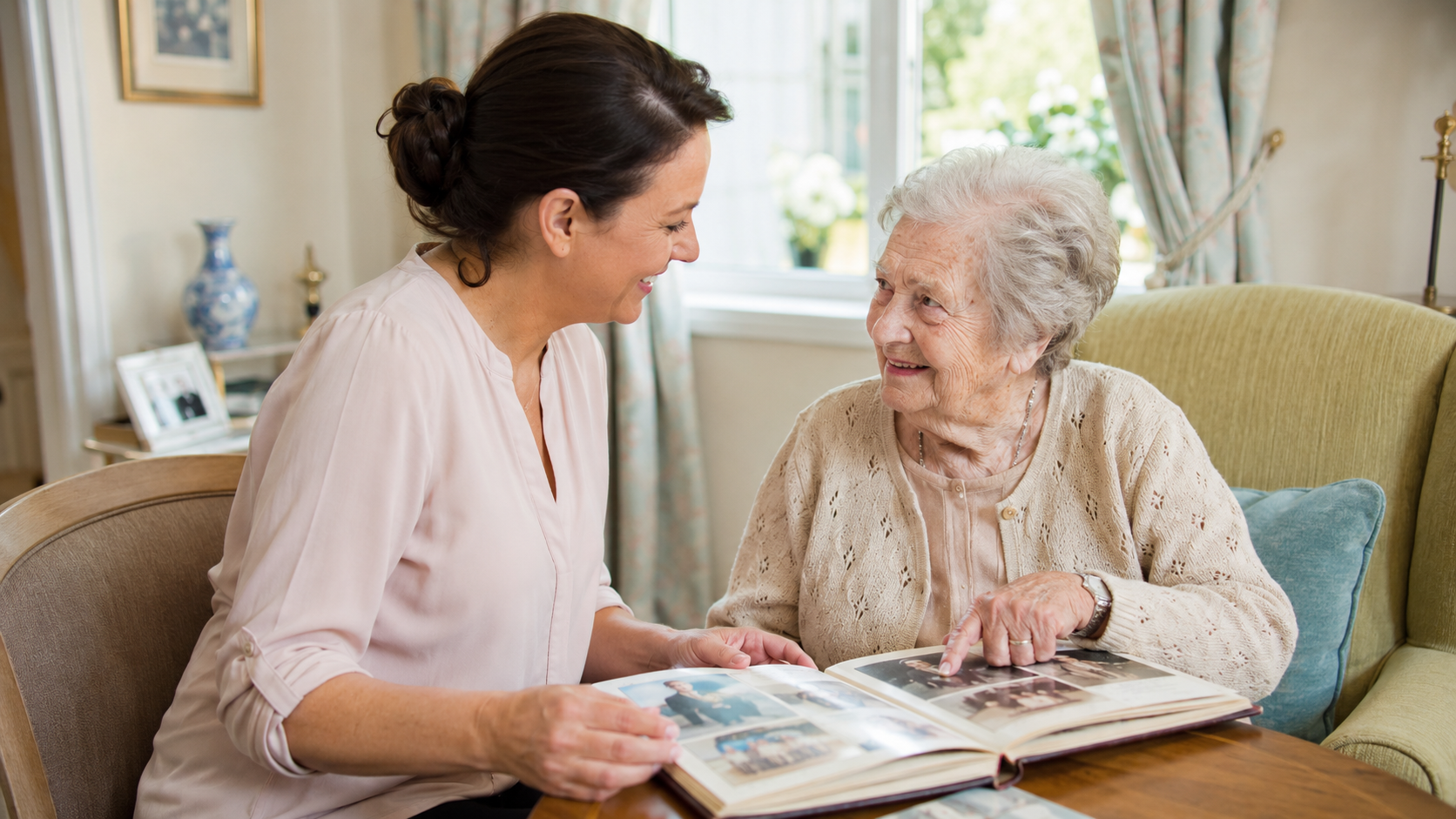 Caregiver and older adult with dementia looking through a photo album together in a bright care home