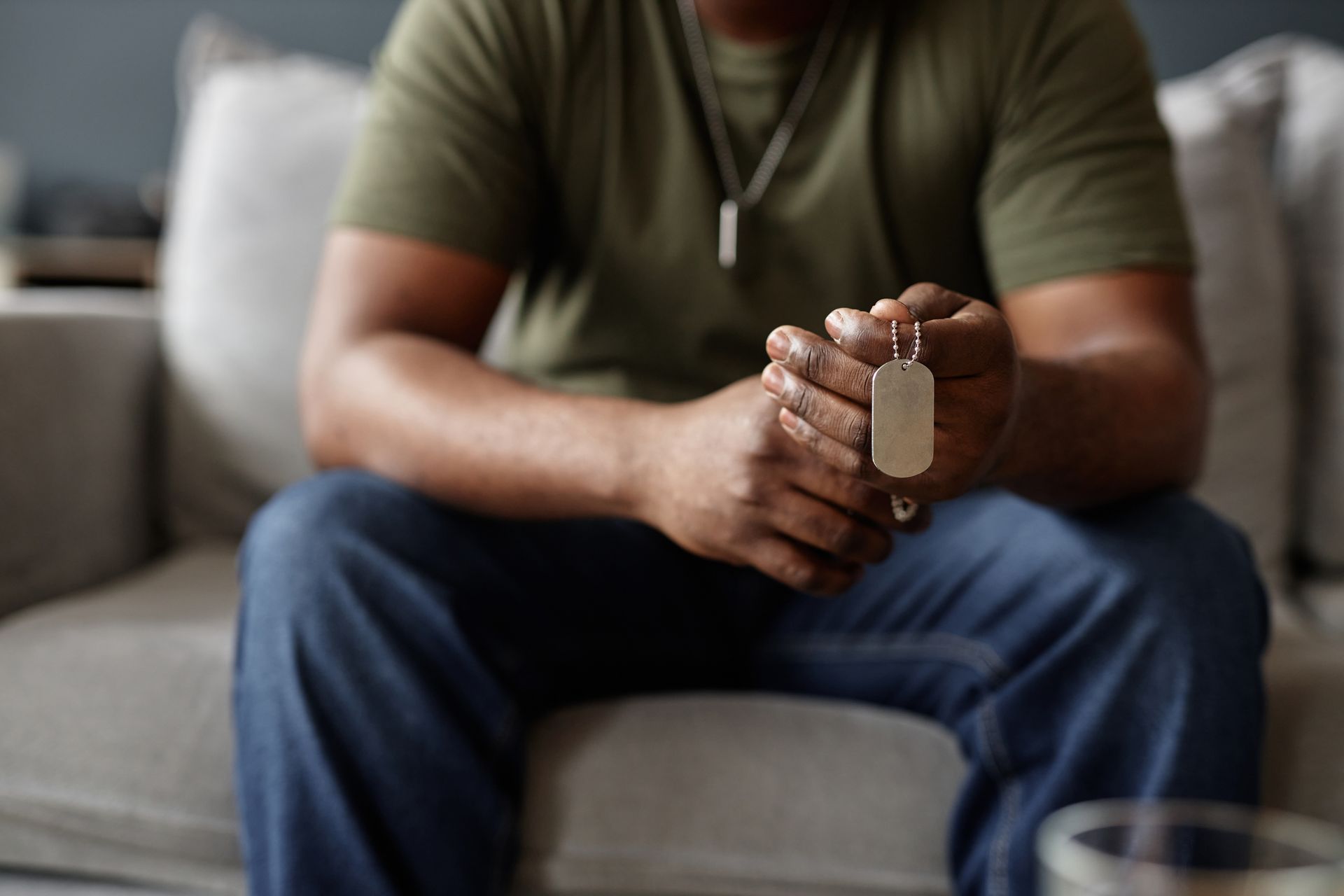 Person sitting on a couch, holding a keychain in a living room.