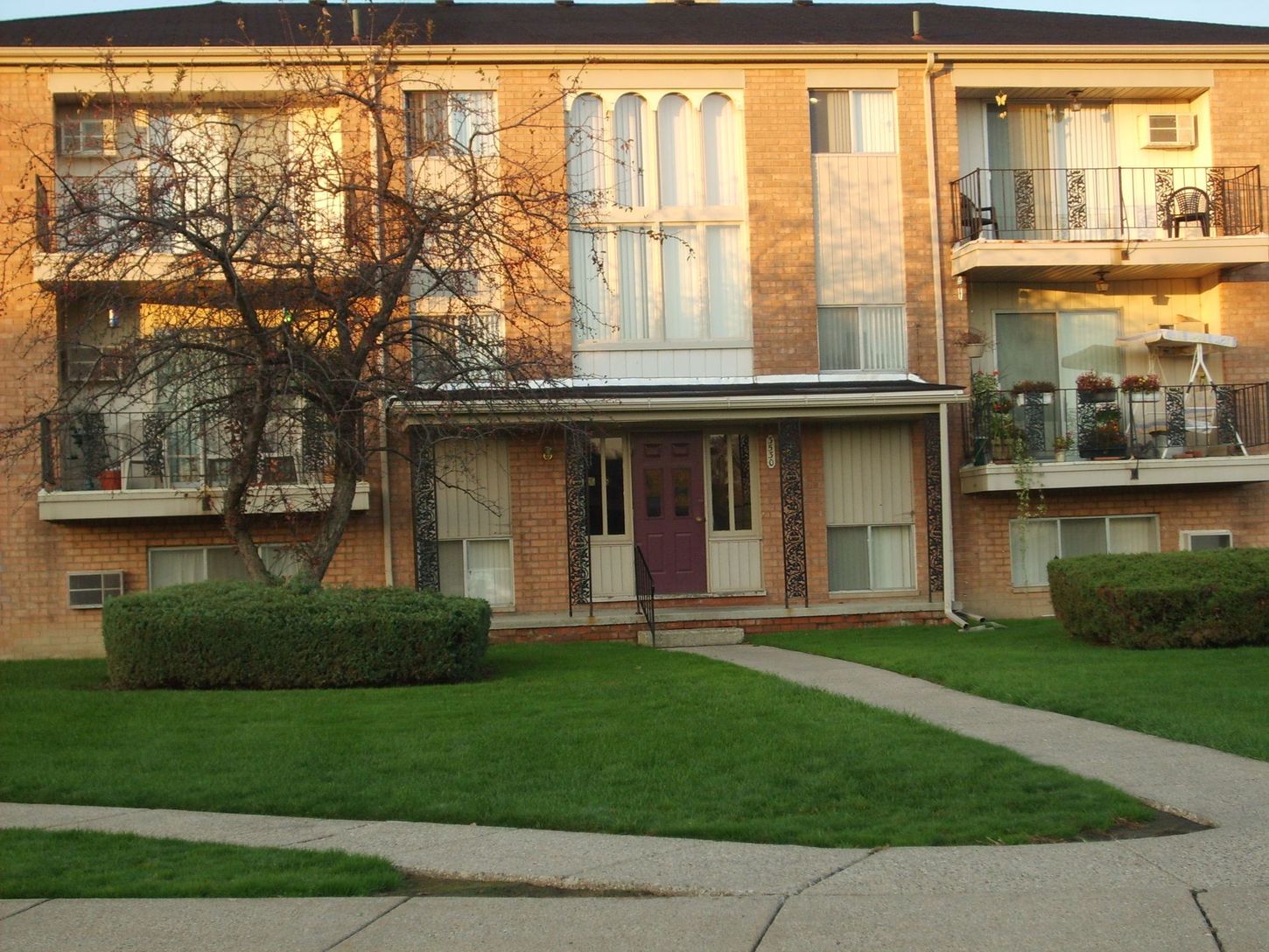 A brick apartment building with a purple door