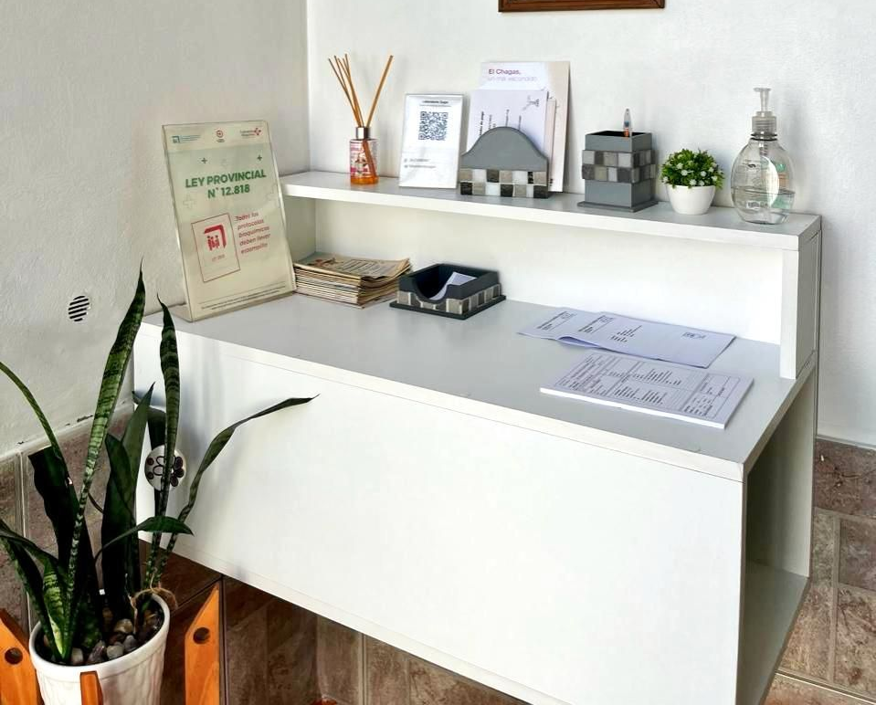 Una sala de exploración estéril y luminosa, con una silla blanca, un soporte médico cubierto con una tela