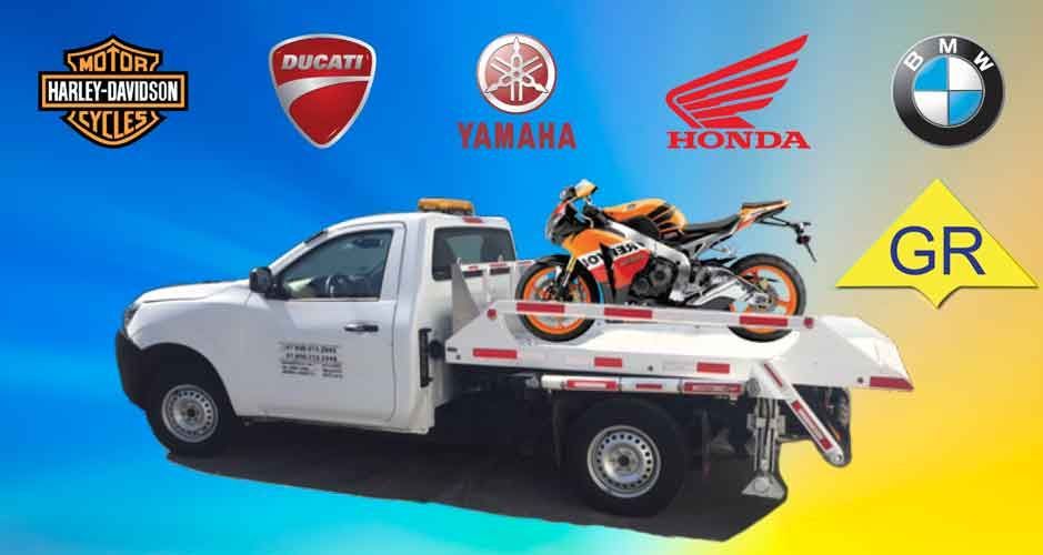 Una grúa con una motocicleta en la parte trasera.