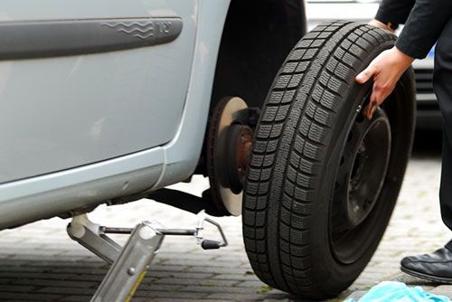 Una persona está cambiando una llanta de un auto