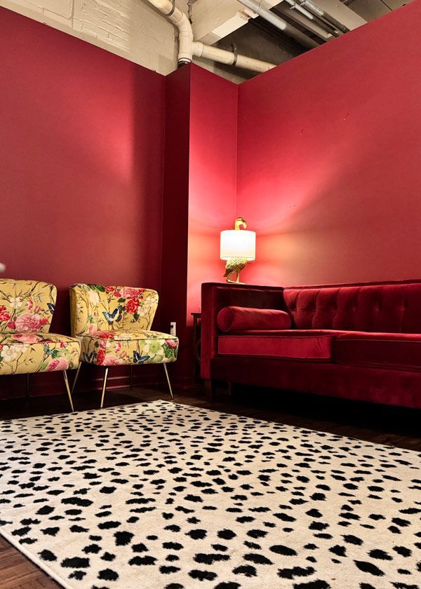 A living room with a couch , chairs , and a dalmatian rug.