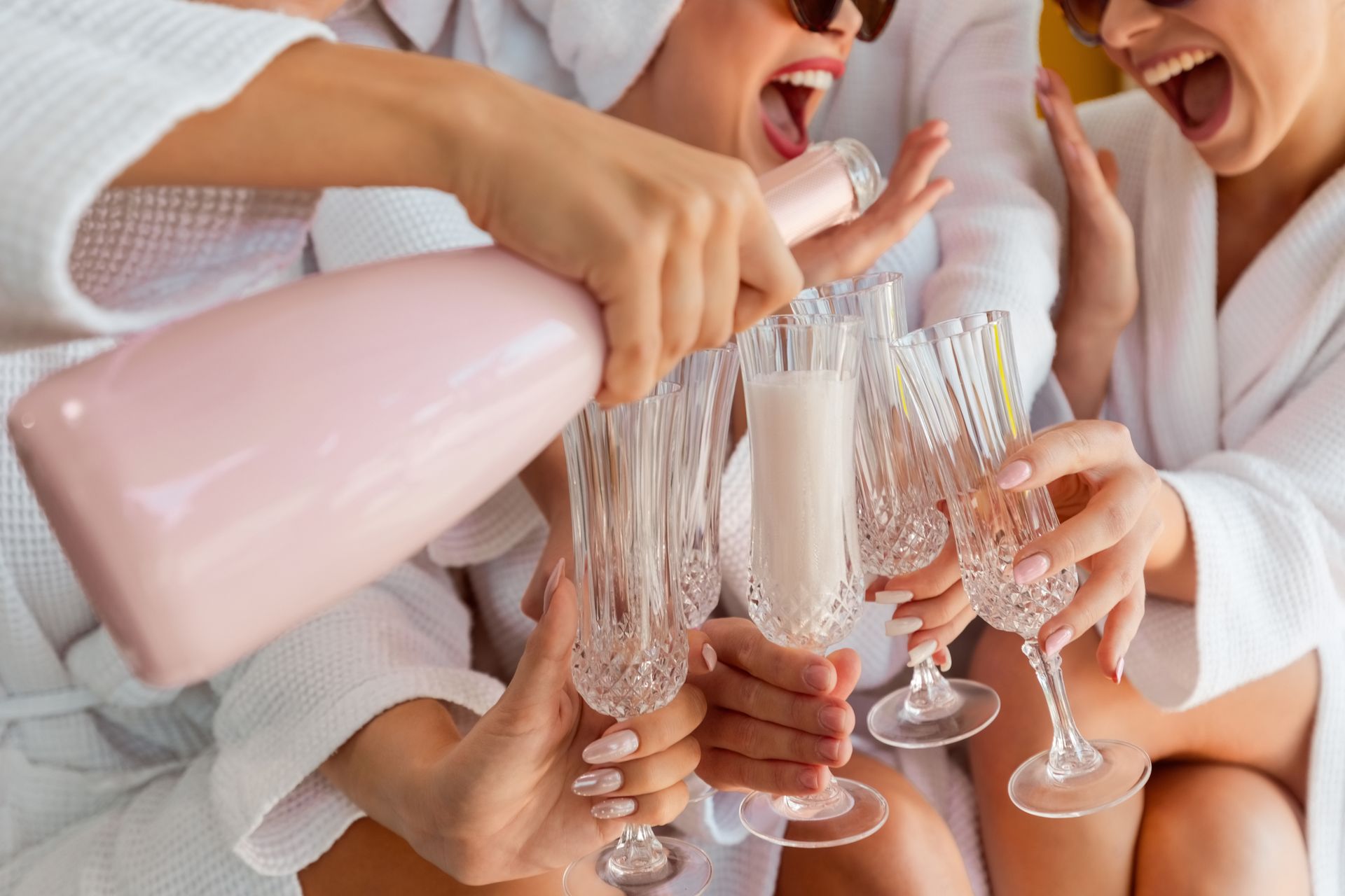 A group of women are toasting with champagne at a bachelorette party.