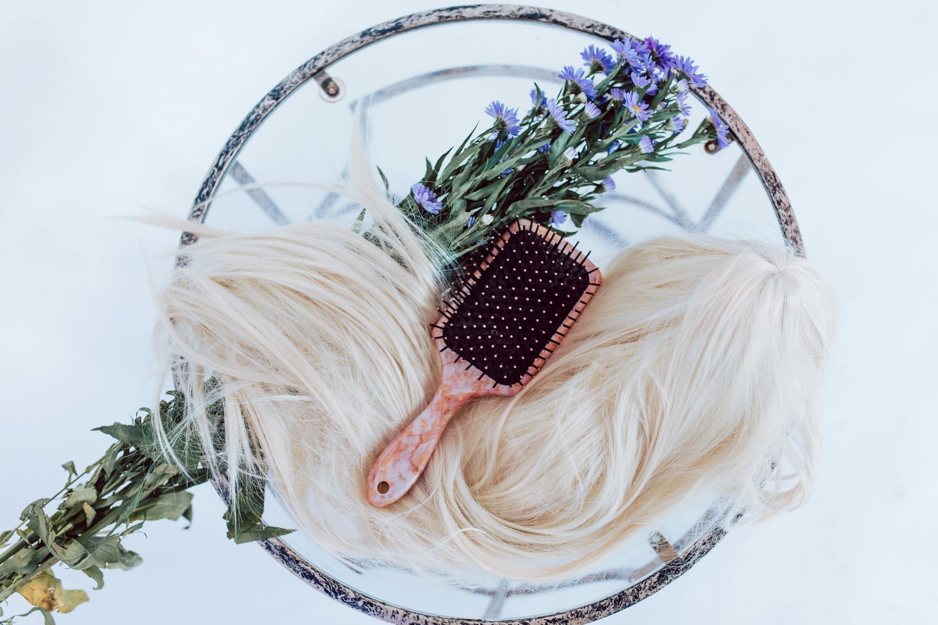 Lavender bouquet with hairbrush and blonde hair on a white round tray