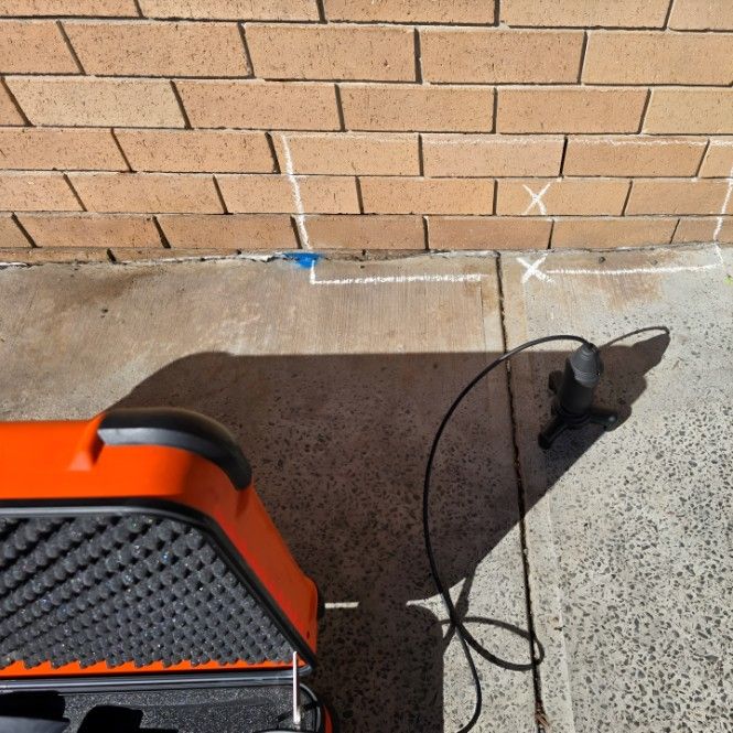 A Brick Wall With Orange Radar Set — Dowds Pipe and Cable Locating in Farmborough Heights, NSW