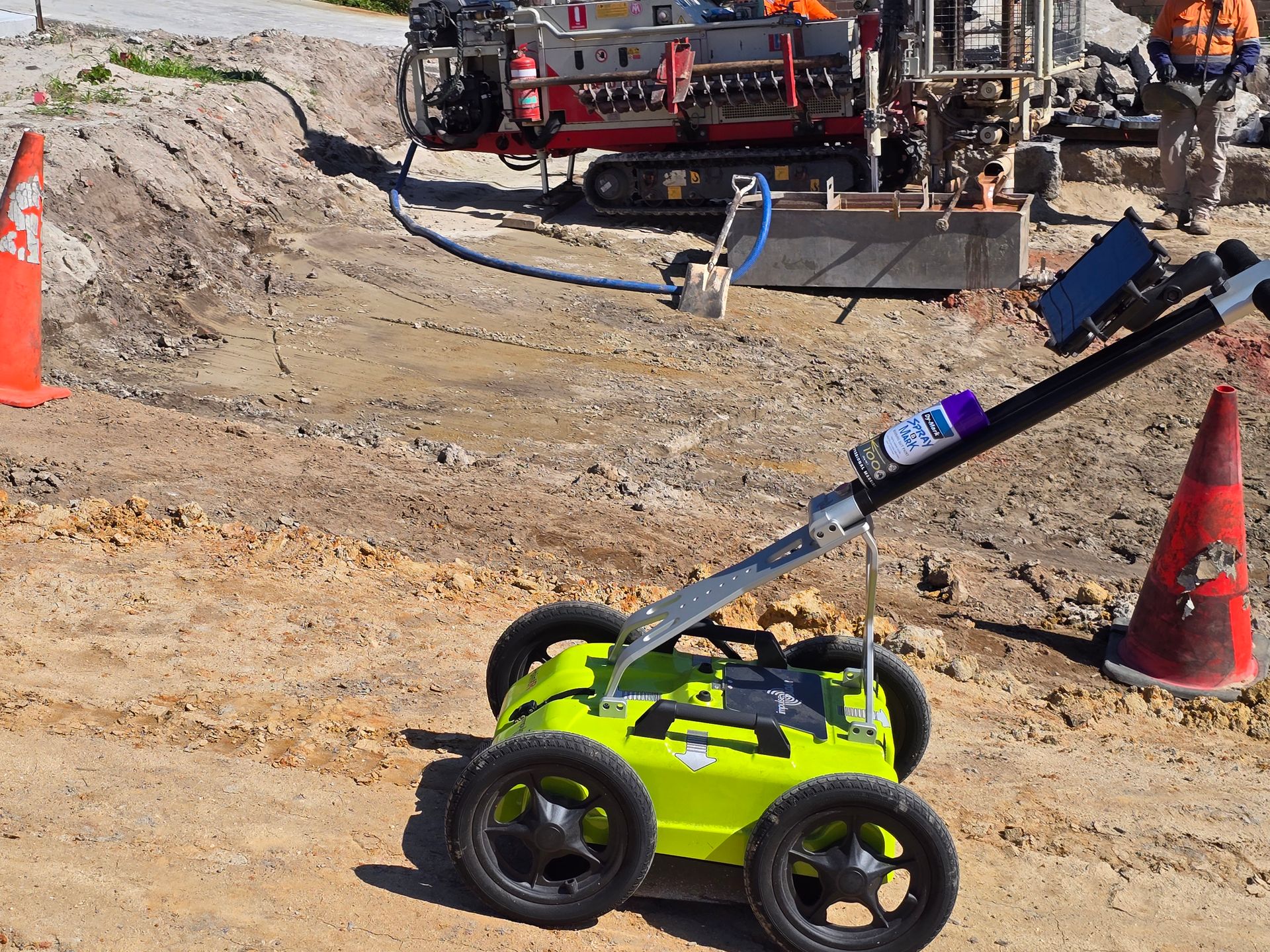 A Green Robot is Sitting on the Ground in a Dirt Field — Dowds Pipe and Cable Locating in Penrith, NSW