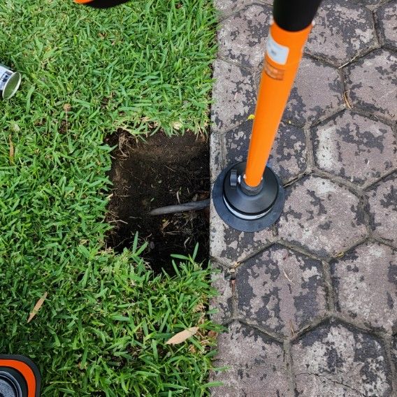 A Radar is Sitting on a Brick Sidewalk Next to a Hole — Dowds Pipe and Cable Locating in Farmborough Heights, NSW