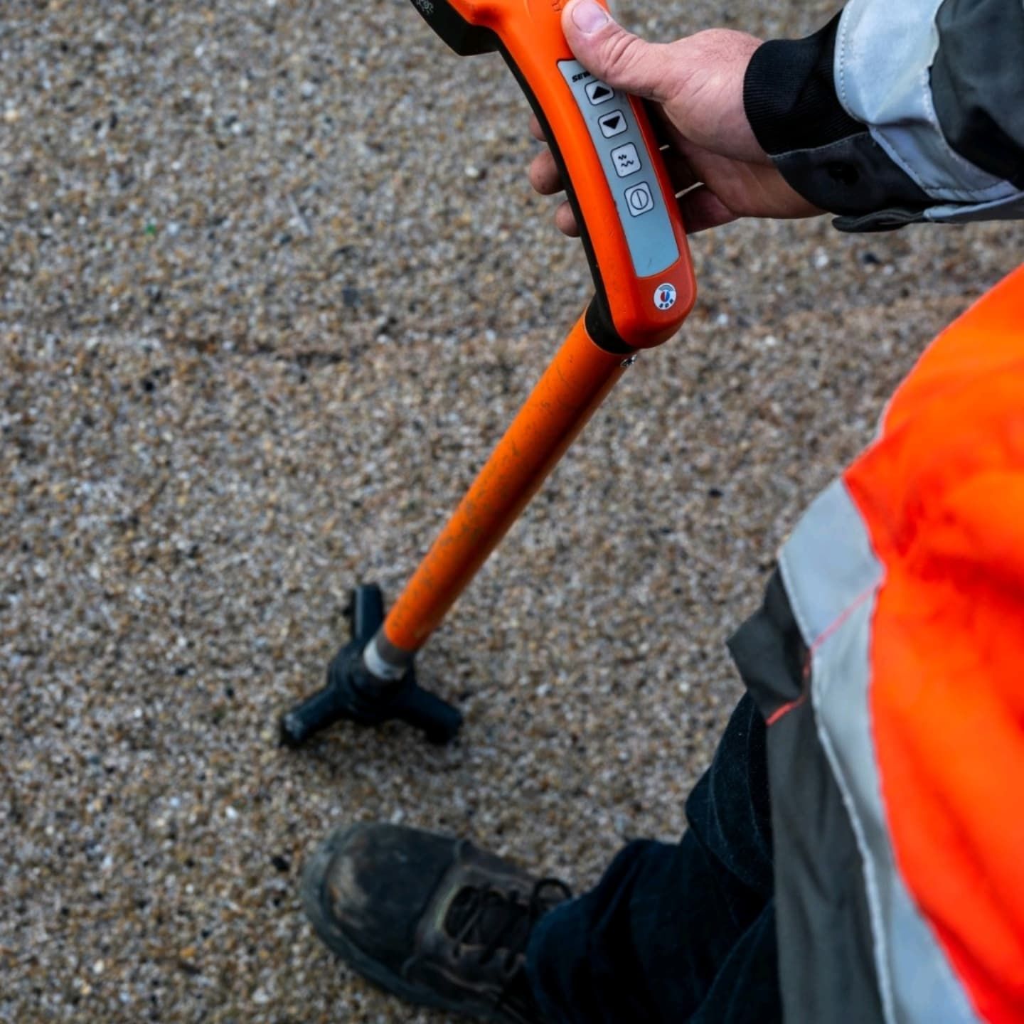 A Person is Holding an Orange Device — Dowds Pipe and Cable Locating in Farmborough Heights, NSW