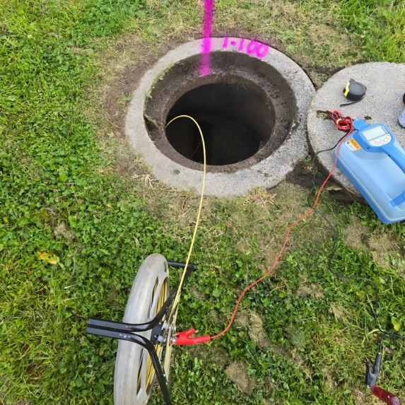 A Manhole Cover With a Camera Attached to It — Dowds Pipe and Cable Locating in Farmborough Heights, NSW