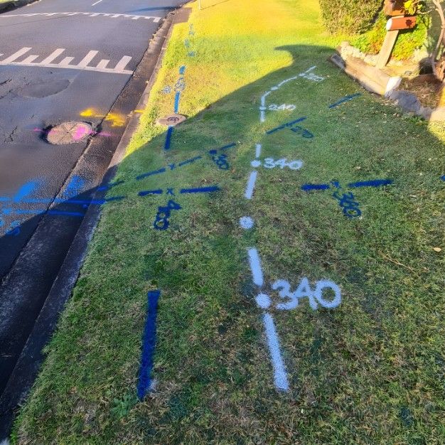 A Grassy Area Next to a Road With Numbers Painted on It — Dowds Pipe and Cable Locating in  Bowral, NSW