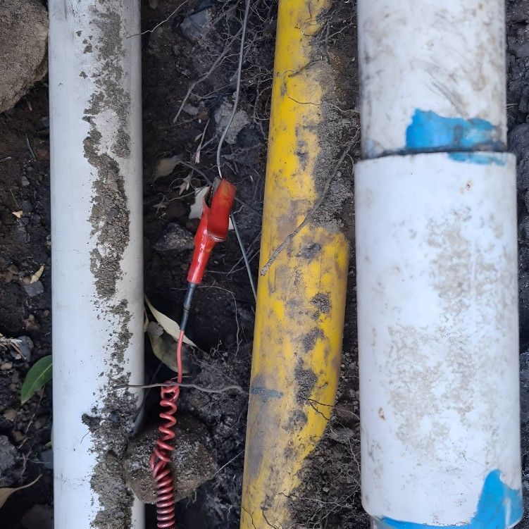 A Yellow Pipe Has a Red Wire Attached to It — Dowds Pipe and Cable Locating in Shellharbour, NSW
