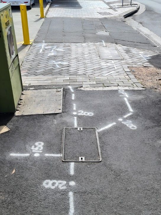 A Manhole Cover is Sitting on the Side of the Road — Dowds Pipe and Cable Locating in Moss Vale, NSW