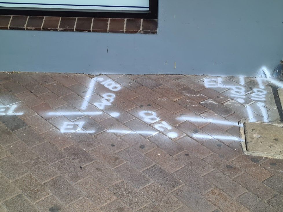 A Brick Sidewalk With Numbers Spray Painted on It — Dowds Pipe and Cable Locating in Campbelltown, NSW