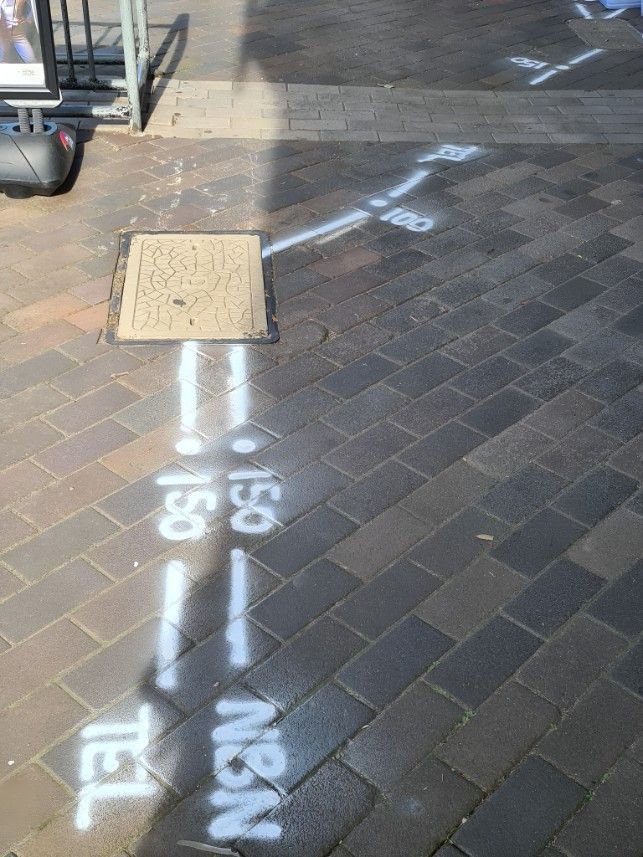A White Line is Painted on a Brick Sidewalk — Dowds Pipe and Cable Locating in Campbelltown, NSW