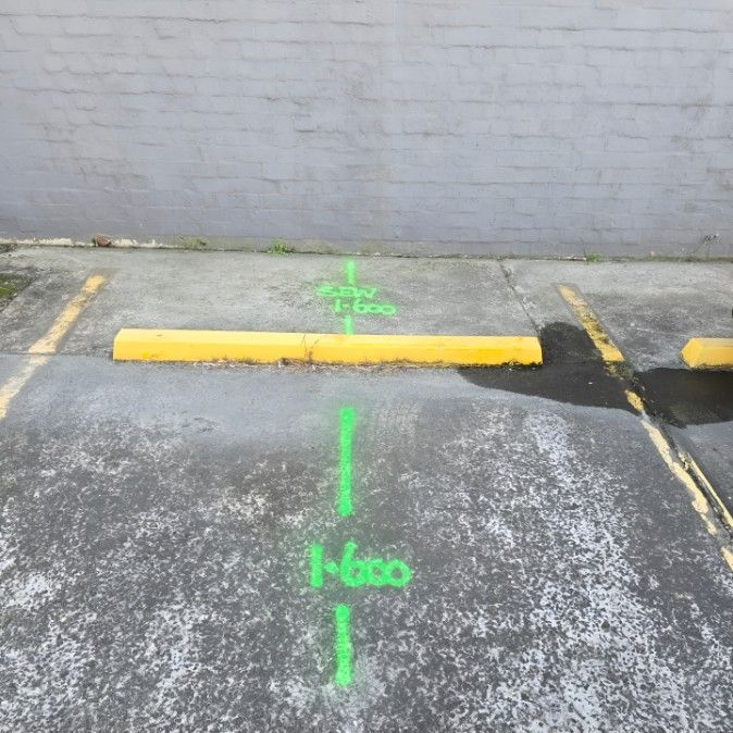 A Parking Lot With a Yellow Curb and a Green Line — Dowds Pipe and Cable Locating in Goulburn, NSW