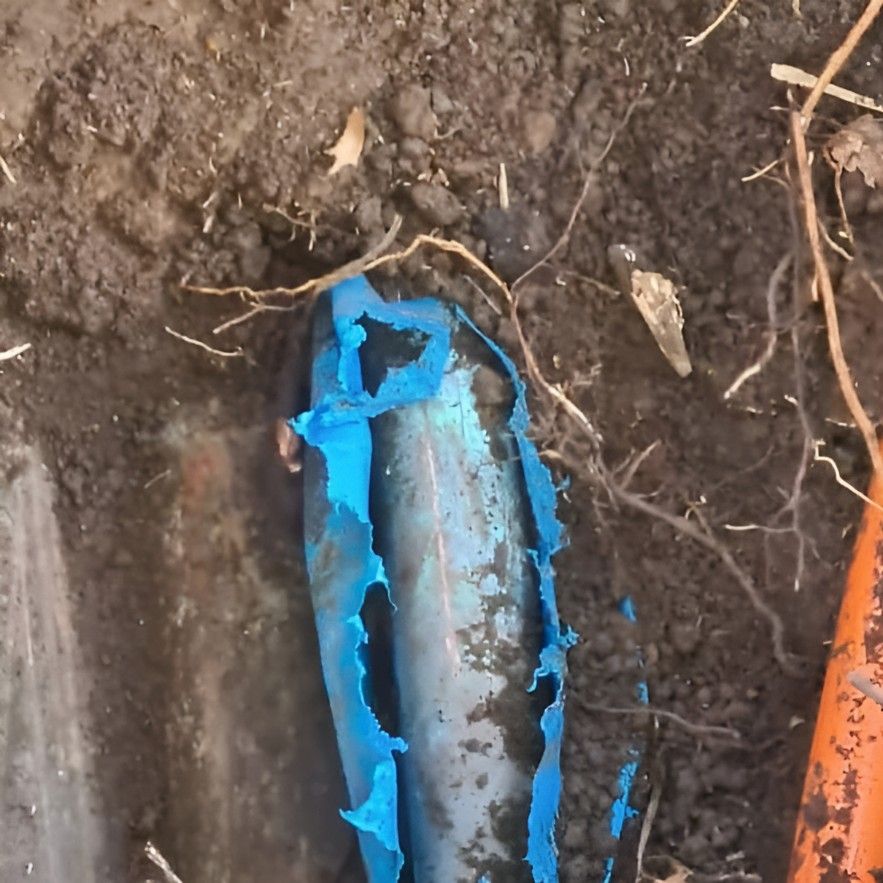 A Blue Pipe is Laying in the Dirt Next to an Orange Pipe — Dowds Pipe and Cable Locating in Ulladulla, NSW